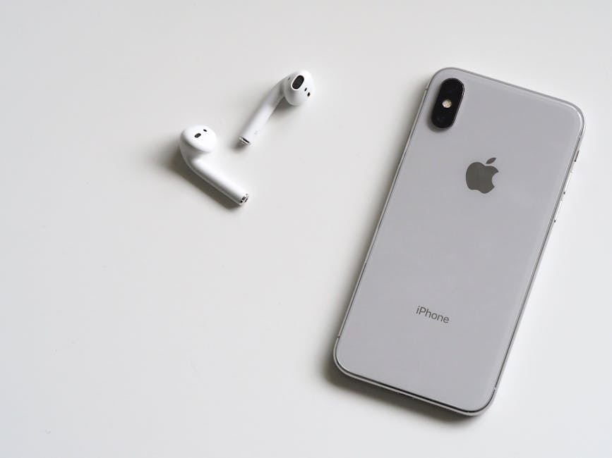 Srebrni iPhone i bežične AirPods slušalice